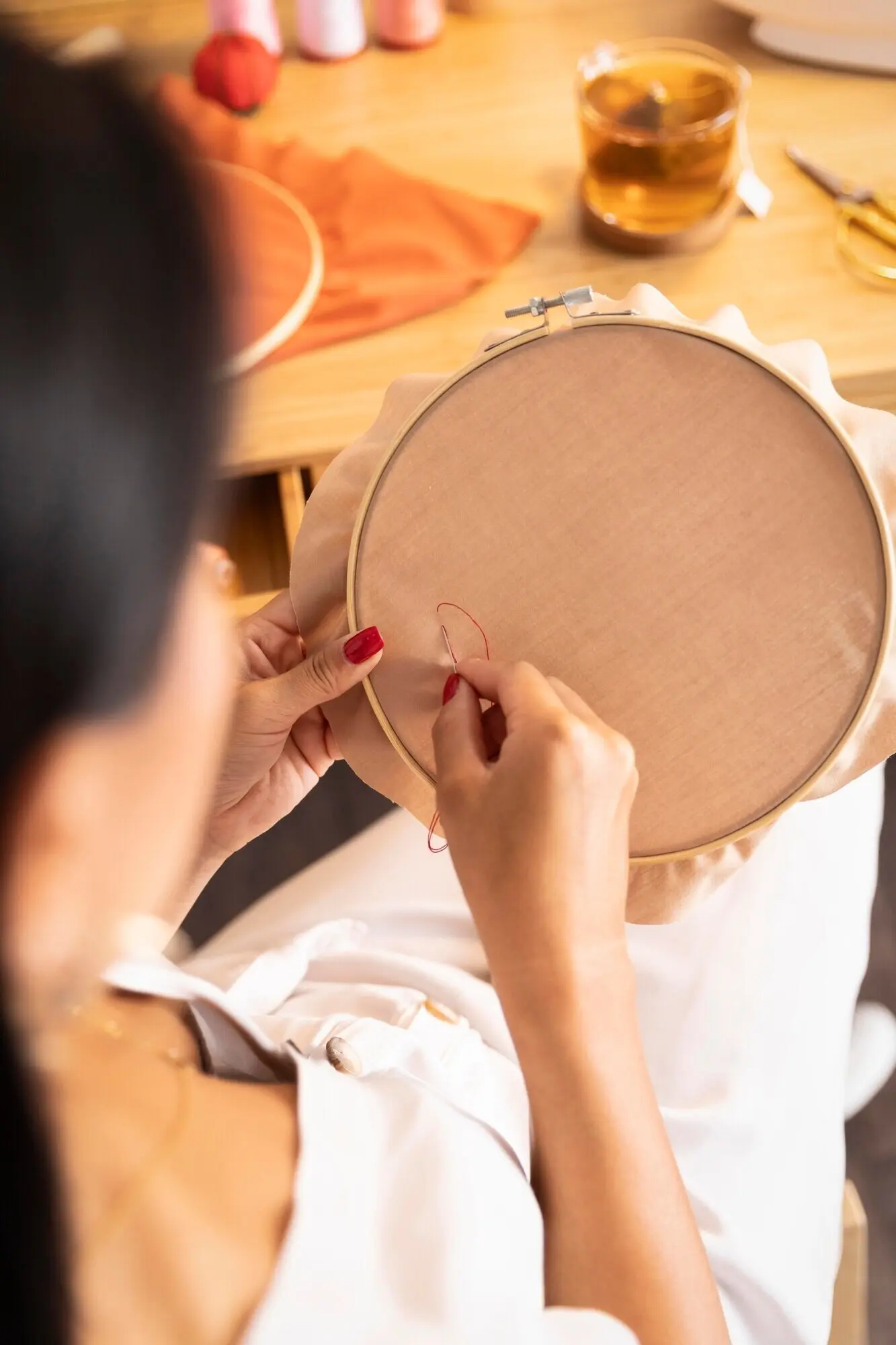 Nahaufnahme einer Frau, die drinnen näht.