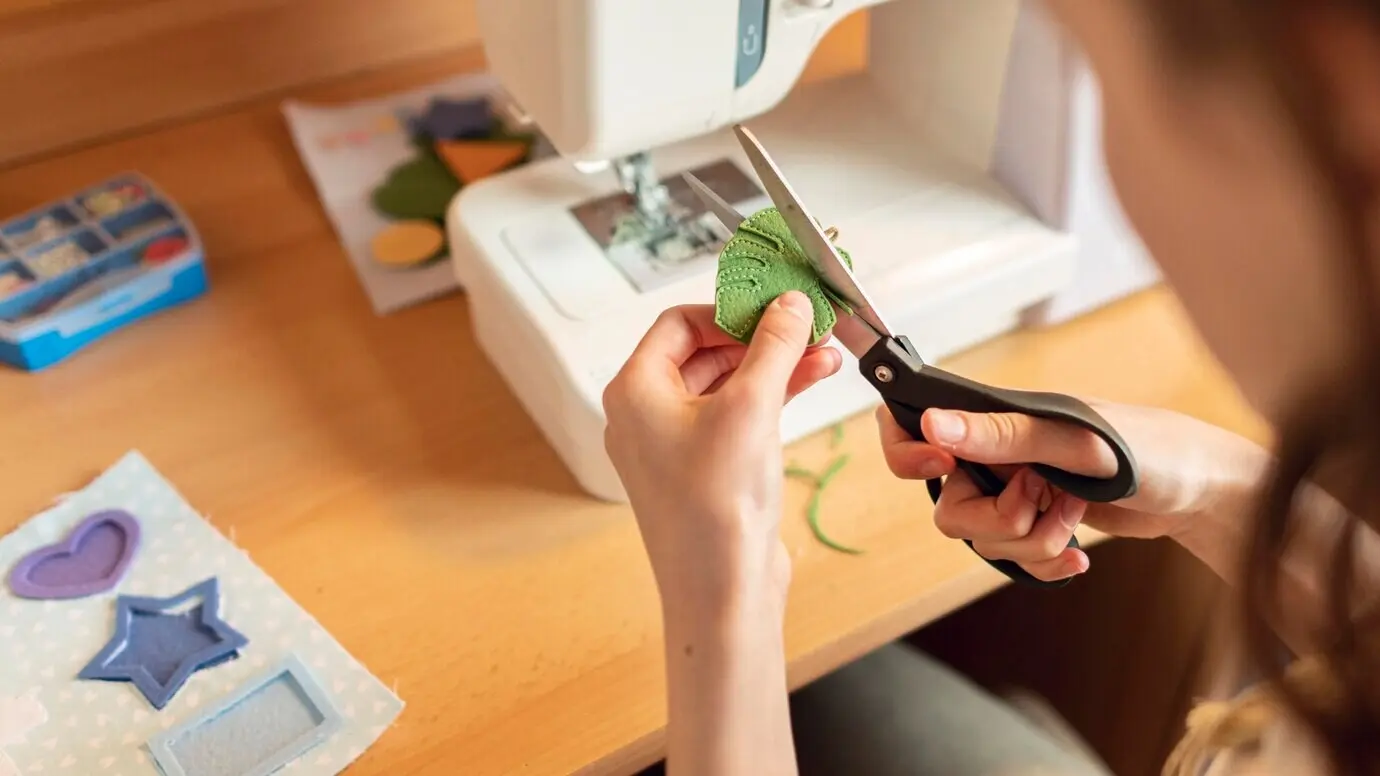 Nahaufnahme einer Frau beim Schneiden eines Blattes.