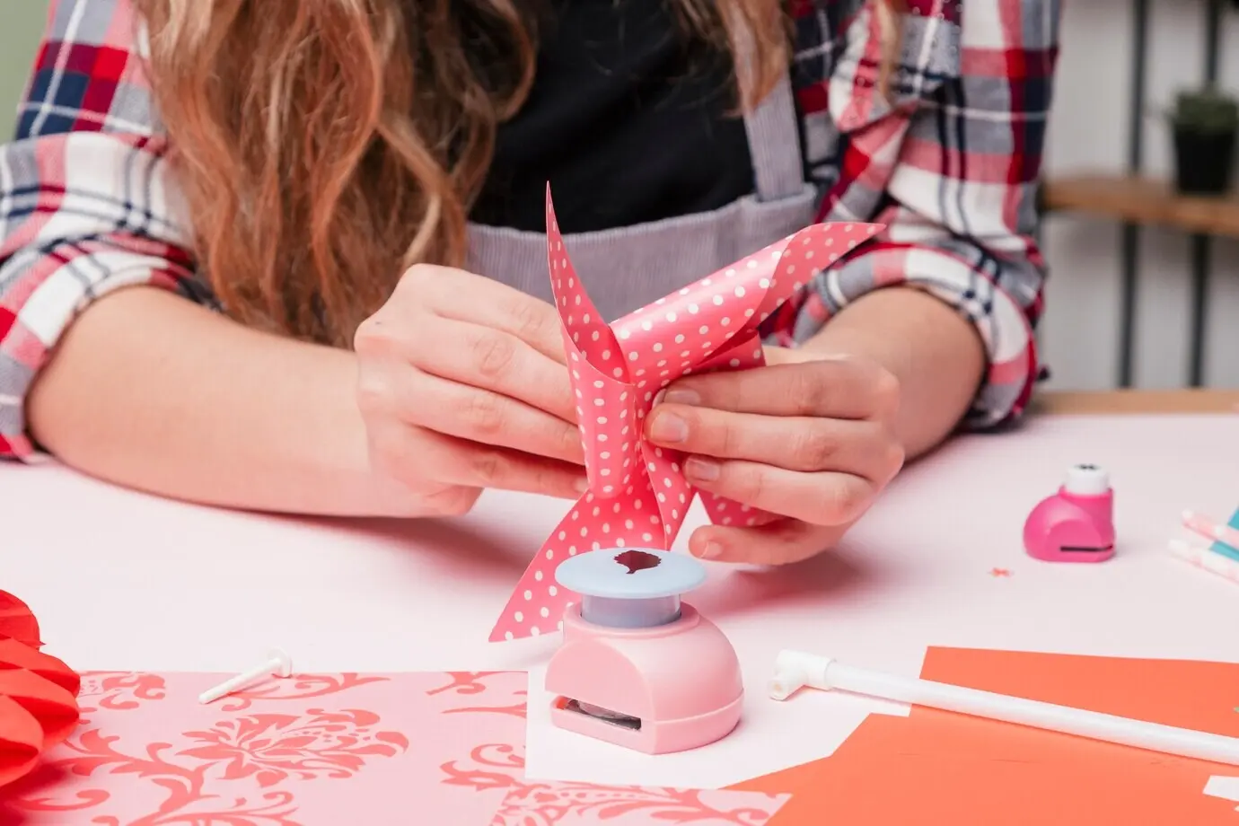 Hand einer Künstlerin beim Basteln eines Windrads.